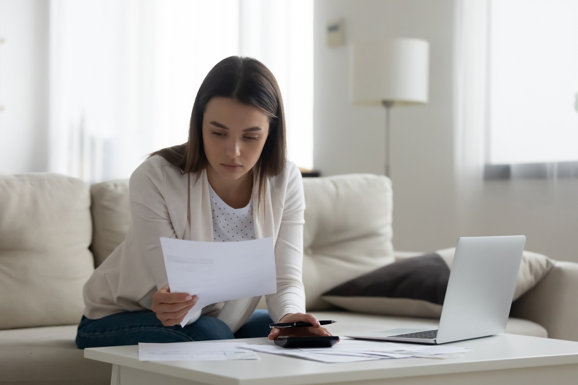 Bookkeeper working with invoices, calculates expenses doing work at home