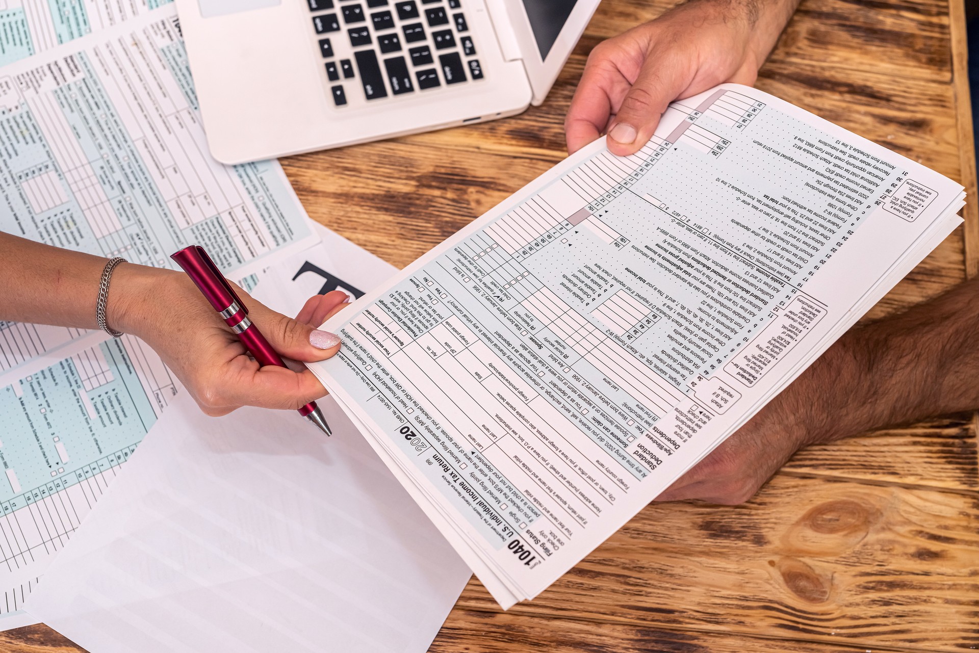 two employees at work fill out tax forms 1040 at the office desk.